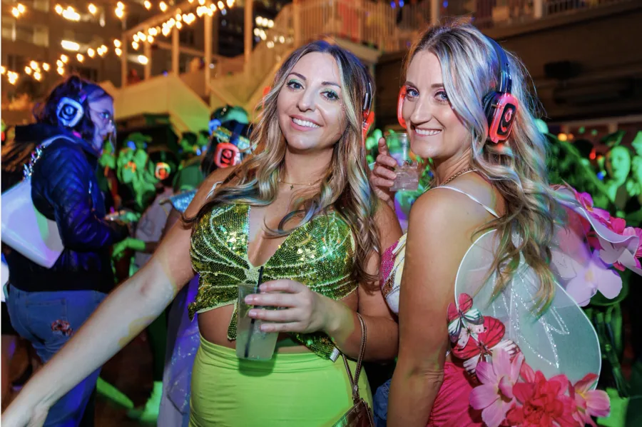 Two costumed women wearing headphones at a Quiet Events Halloween party